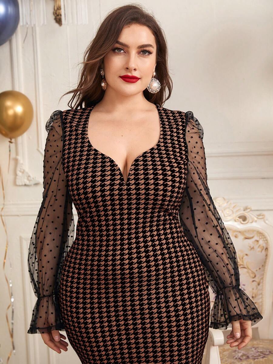 Plus size woman in elegant black and brown houndstooth dress with sheer polka dot tulle sleeves.